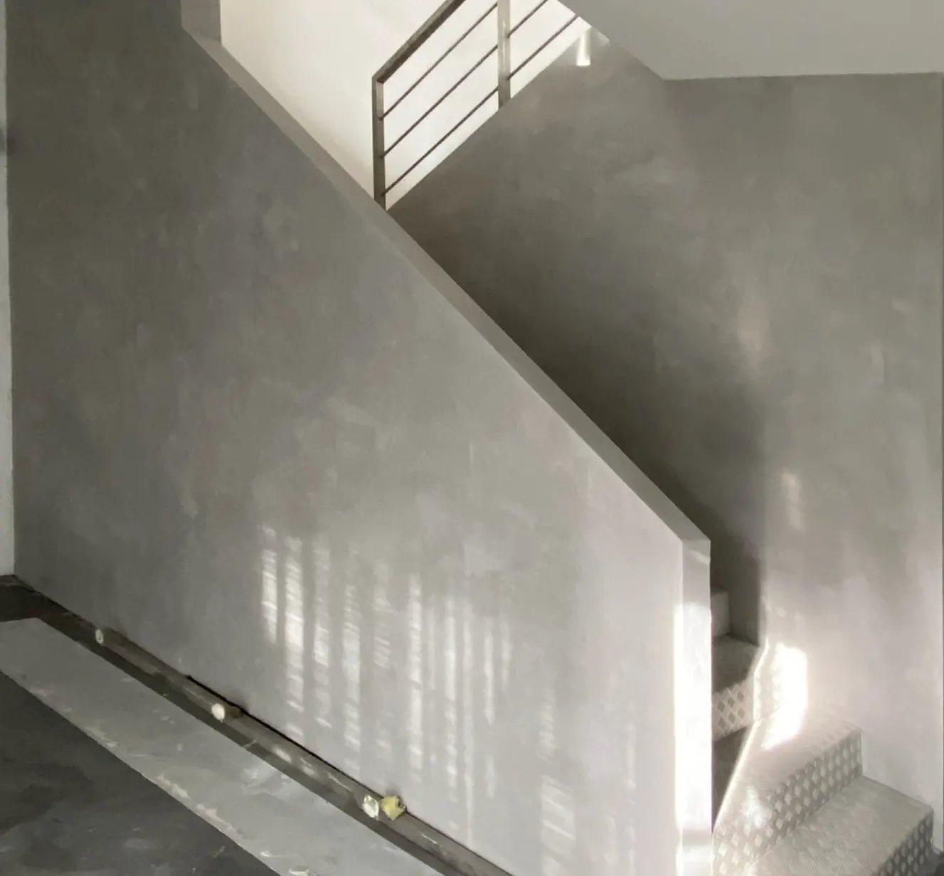 Escada com parede em marmorino cinza de textura fina
