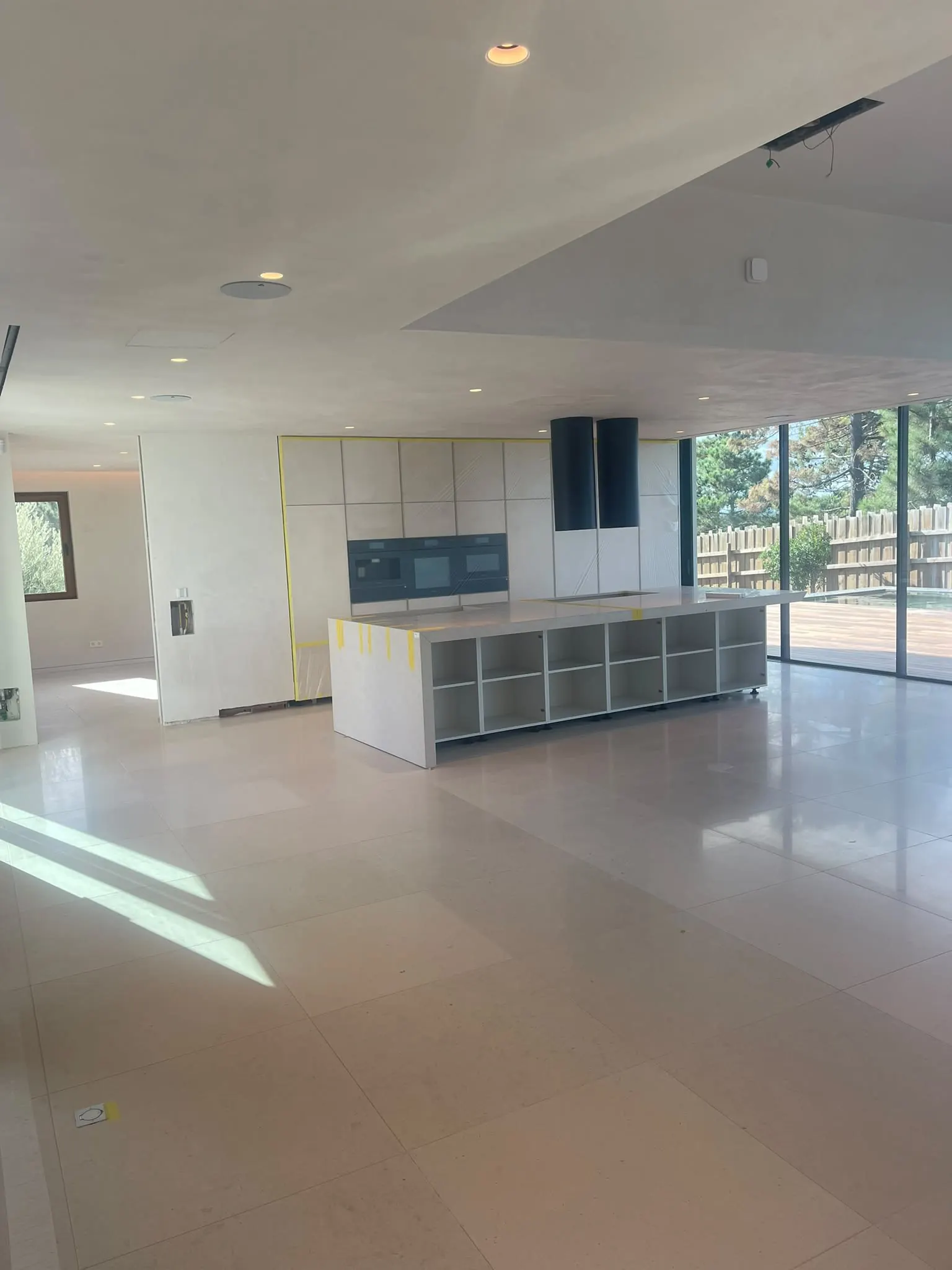 Cozinha em open space com pavimento contínuo e ilha branca